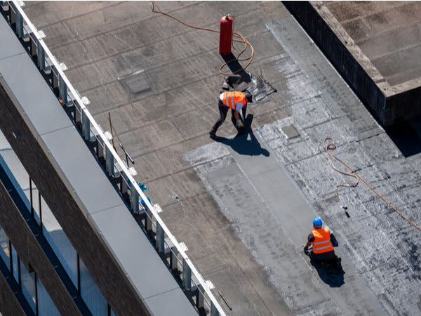 Professional bitumen waterproofing on a flat building.